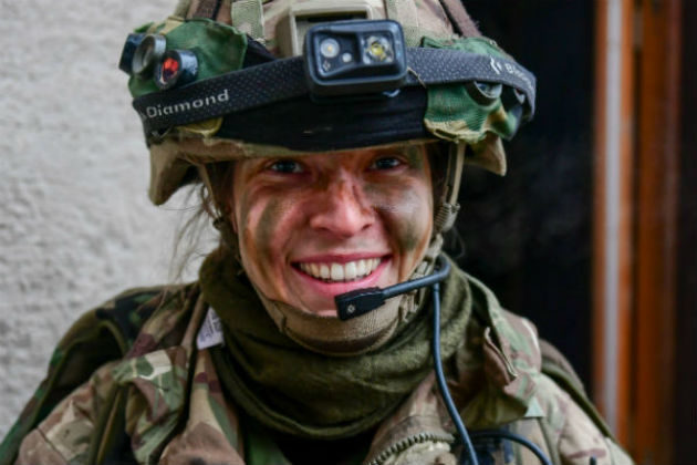 Headshot of a woman smiling wearing army uniform.