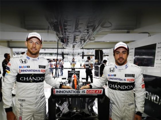 Two racing drivers leaning on a sign: Innovation is GREAT.