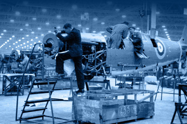 An aged photograph of Royal Air Force crew working on aircraft in a large hanger.