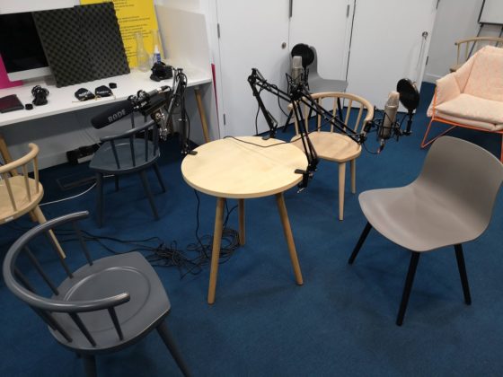 The GDS in-person podcast recording set up. Three chairs set around a small table with individual microphones set up for each guest.