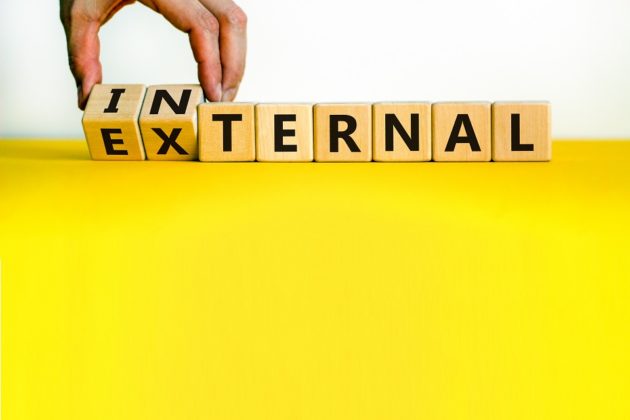 Male hand flips wooden cubes and changes the word 'external' to 'internal'.