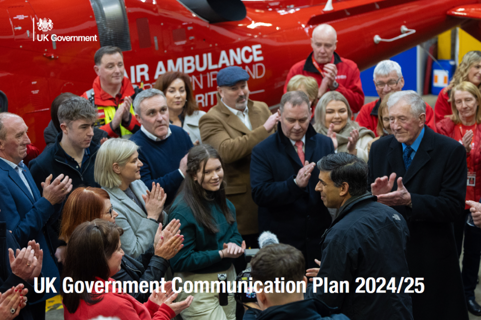 UK Government Communication Plan 2024/25 written white text over the top of a picture of PM Rishi Sunak talking to crowds of people with Air Ambulance in the background