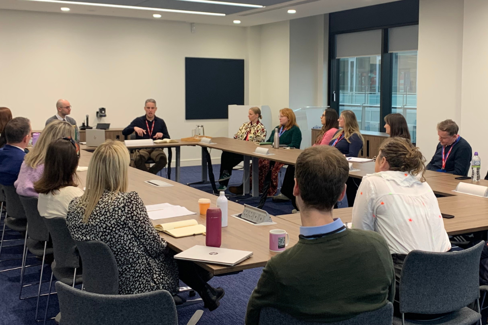 GCS Chief Executive, Simon Baugh, sitting at a table in a meeting room with GCS members from the Scotland GCS community