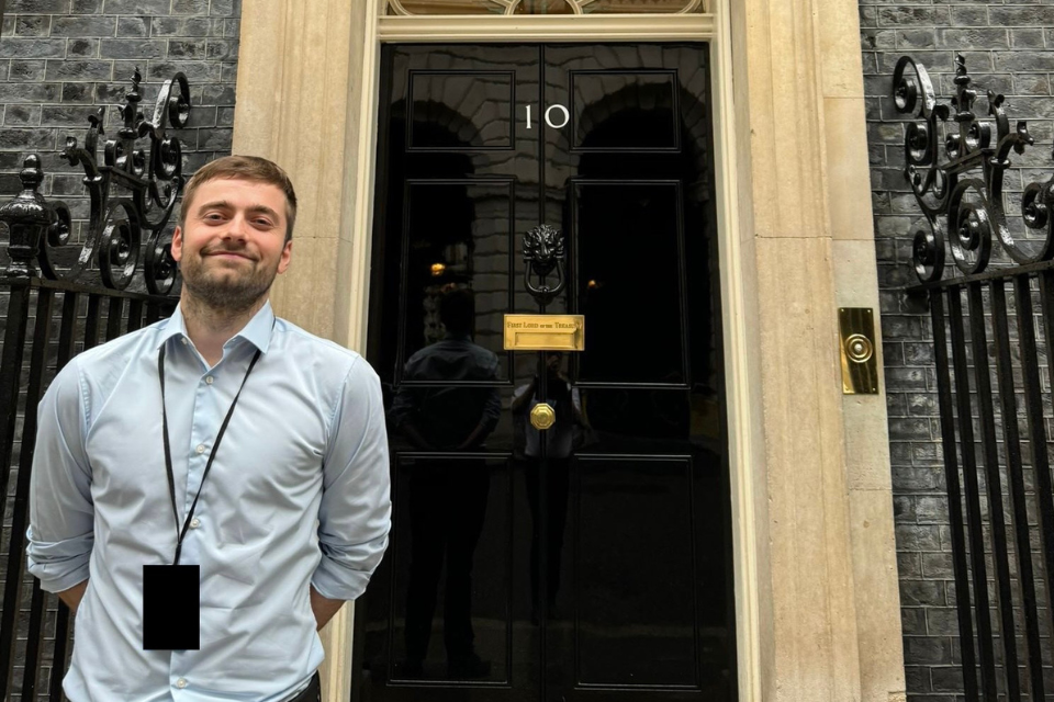 Close-up of Marcus Melton stood in front of the 10 Downing Street front door.